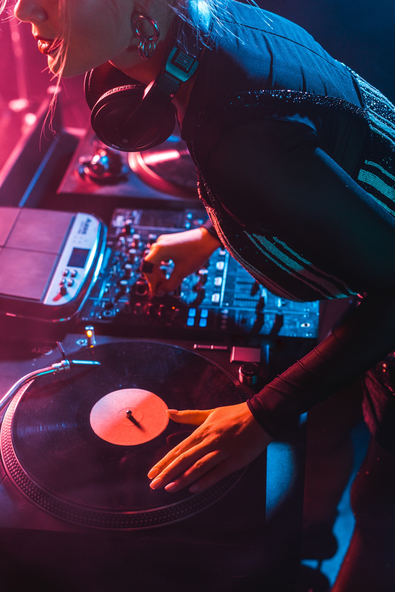 cropped view of focused dj woman using dj equipment in nightclub